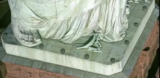 Top view of broken shackles and chains at feet of Lady Liberty